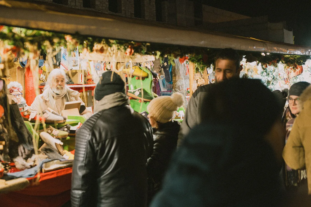 Christmas market stalls lit at dusk in Trento